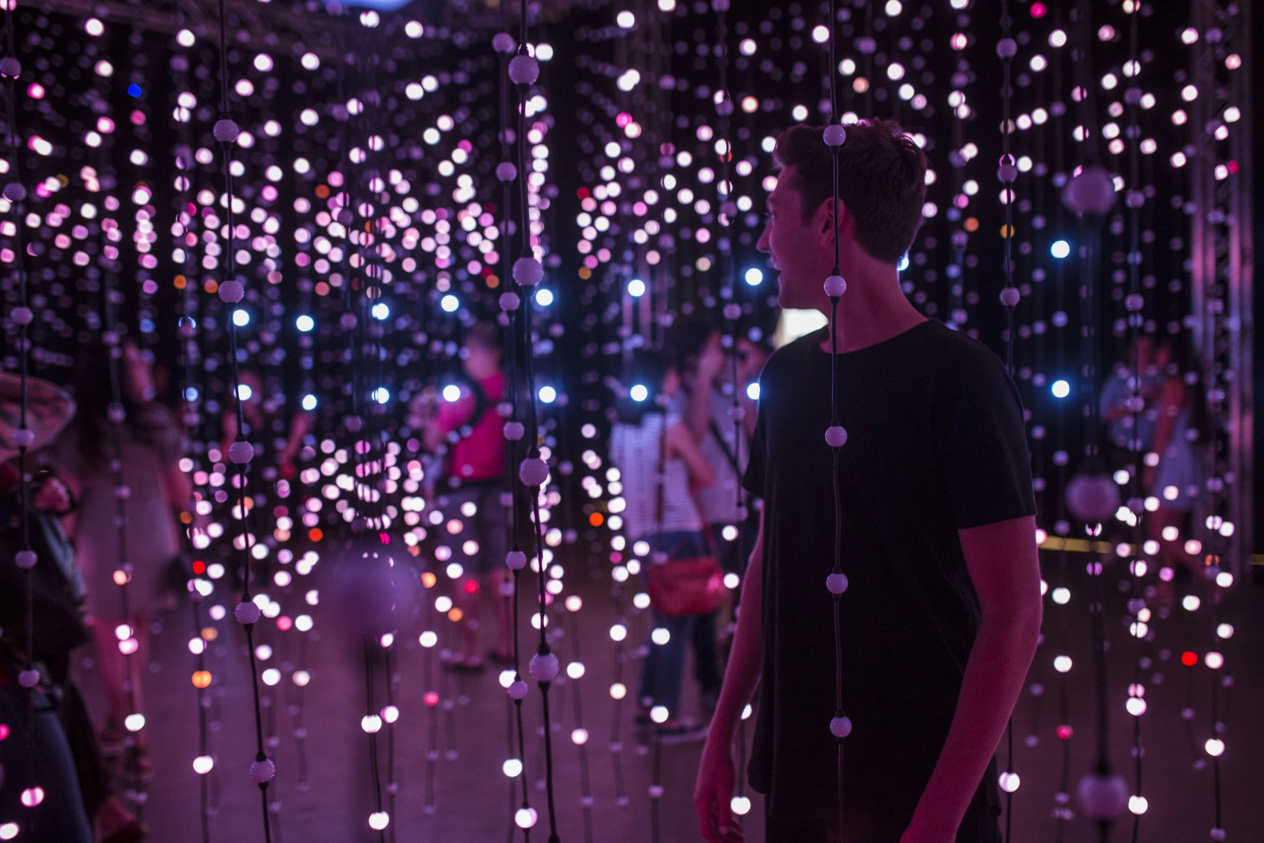 Submergence — visitors walking through thousands of points of colored light
